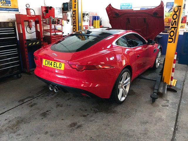 Red Jaguar F-Type being worked on in the workshop